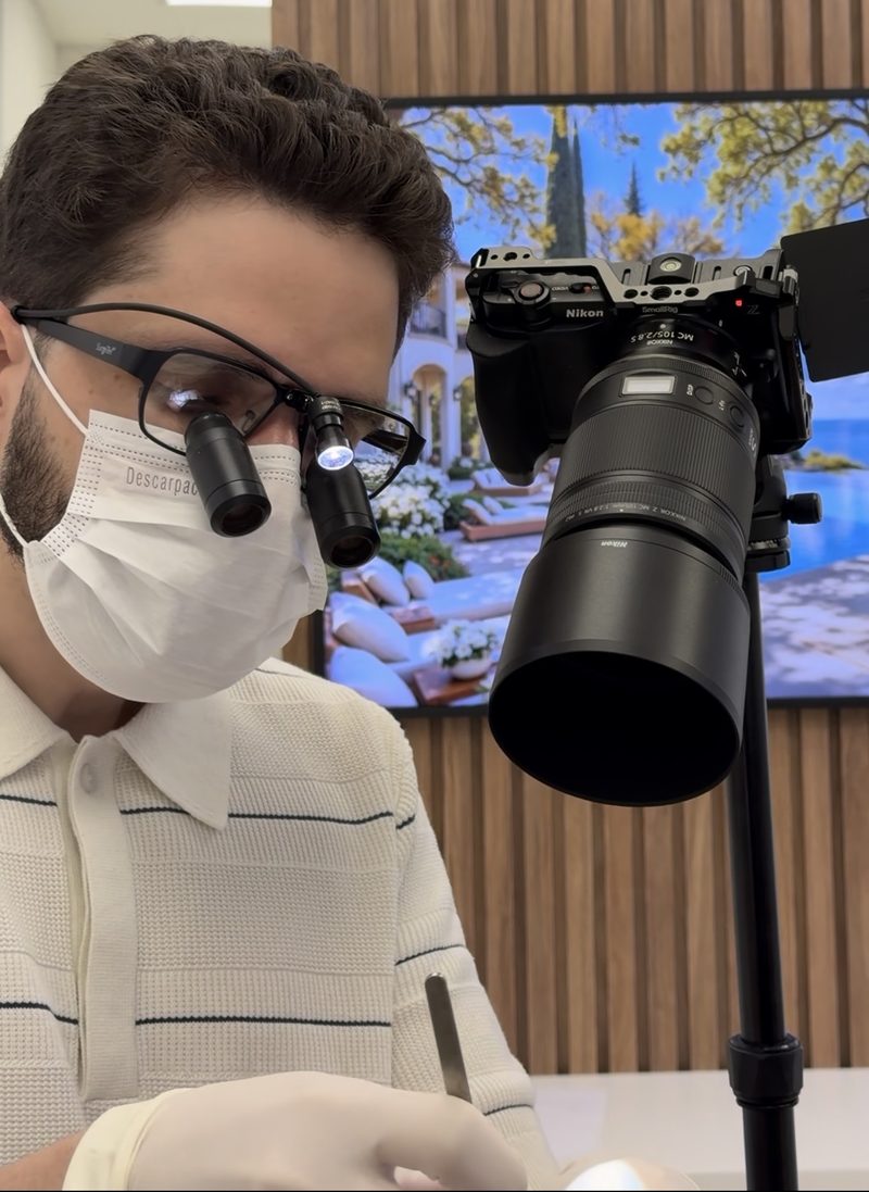 Dr. Caio Formiga com as lupas cirúrgicas e a câmera macro